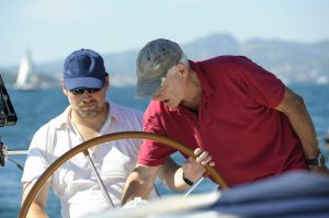 Senior Sailing Instructor Giving Advice Aboard Yacht